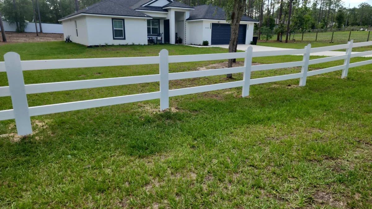 White 3-rail vinyl horse fence framing residential home — Ocala FL