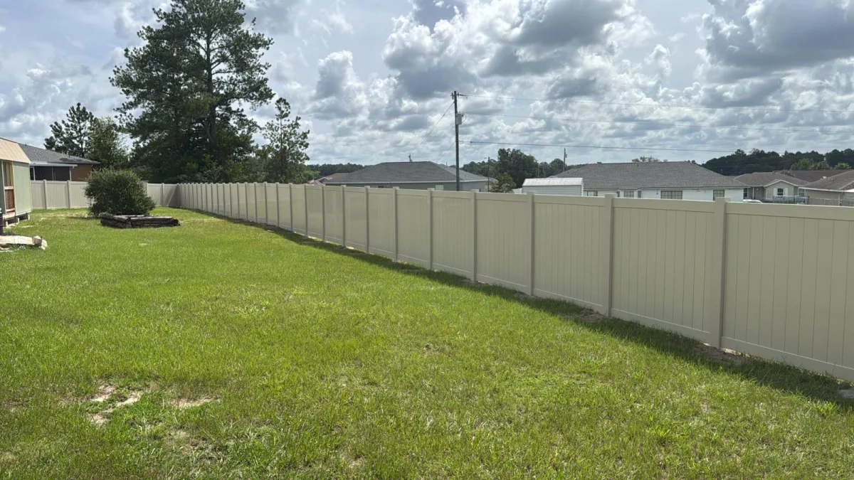 White vinyl privacy fence with driveway gate next to garage — Ocala FL